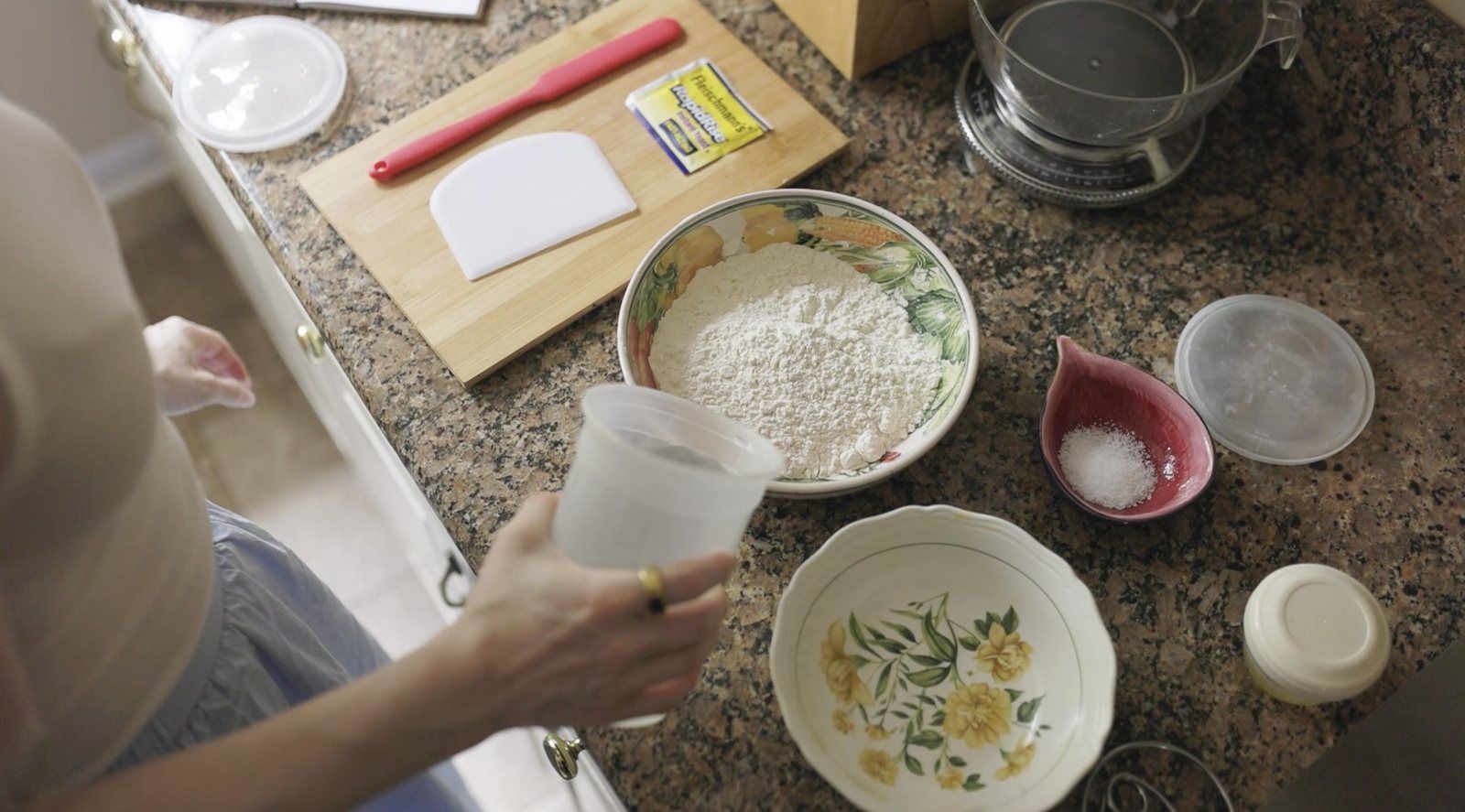 Flour, salt and water measured out for a batch of dough on a kitchen counter.